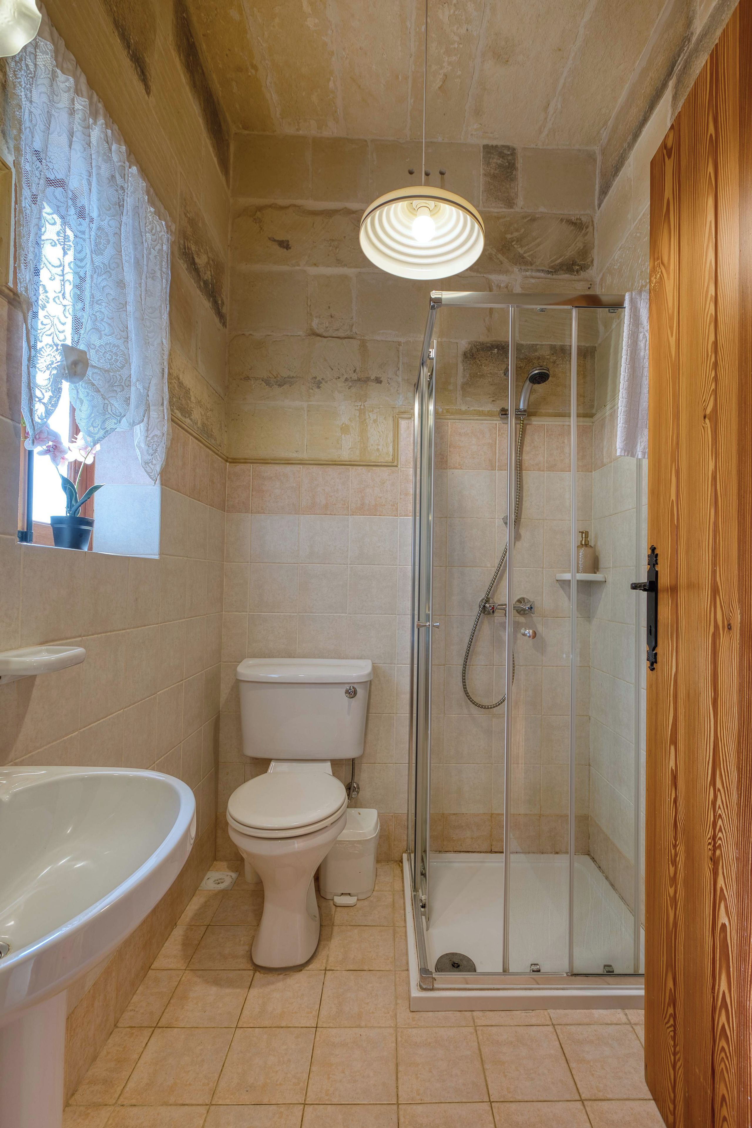 Un baño con inodoro, lavamanos y ducha.