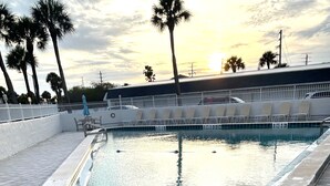 A rectangular pool with a blue handrail, surrounded by a tiled deck. -  2-bedroom condo in charming Cape Canaveral with amazing ocean views (Cape Canaveral)
