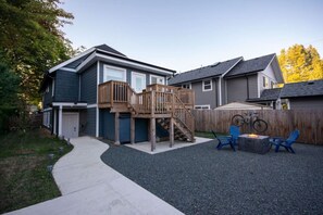 Een wooneiland met een tweelaags huis, een overdekte patio en een grindpad.