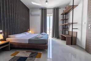Ein modernes Hotelzimmer mit Bett, Nachttisch und einer eingebauten Schrankwand.