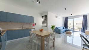 Un appartement moderne comprenant une cuisine, un coin repas et un salon.