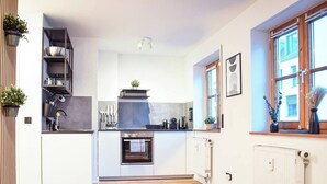 Et moderne køkken med indbyggede hårde hvidevarer, et vindue med udsigt og en trægulv.