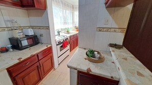 A compact kitchen with a microwave, stove, and cabinets. - Fully furnished apartment in Los Patos, 5 minutes from the Rio de los Patos (Los Patos)