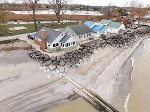 A coastal property with a house, a dock, and a rocky shoreline.