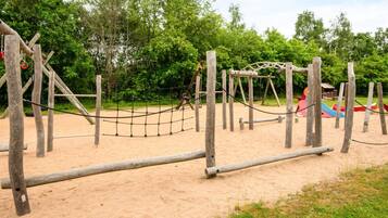 A playground with wooden structures and a rope net.