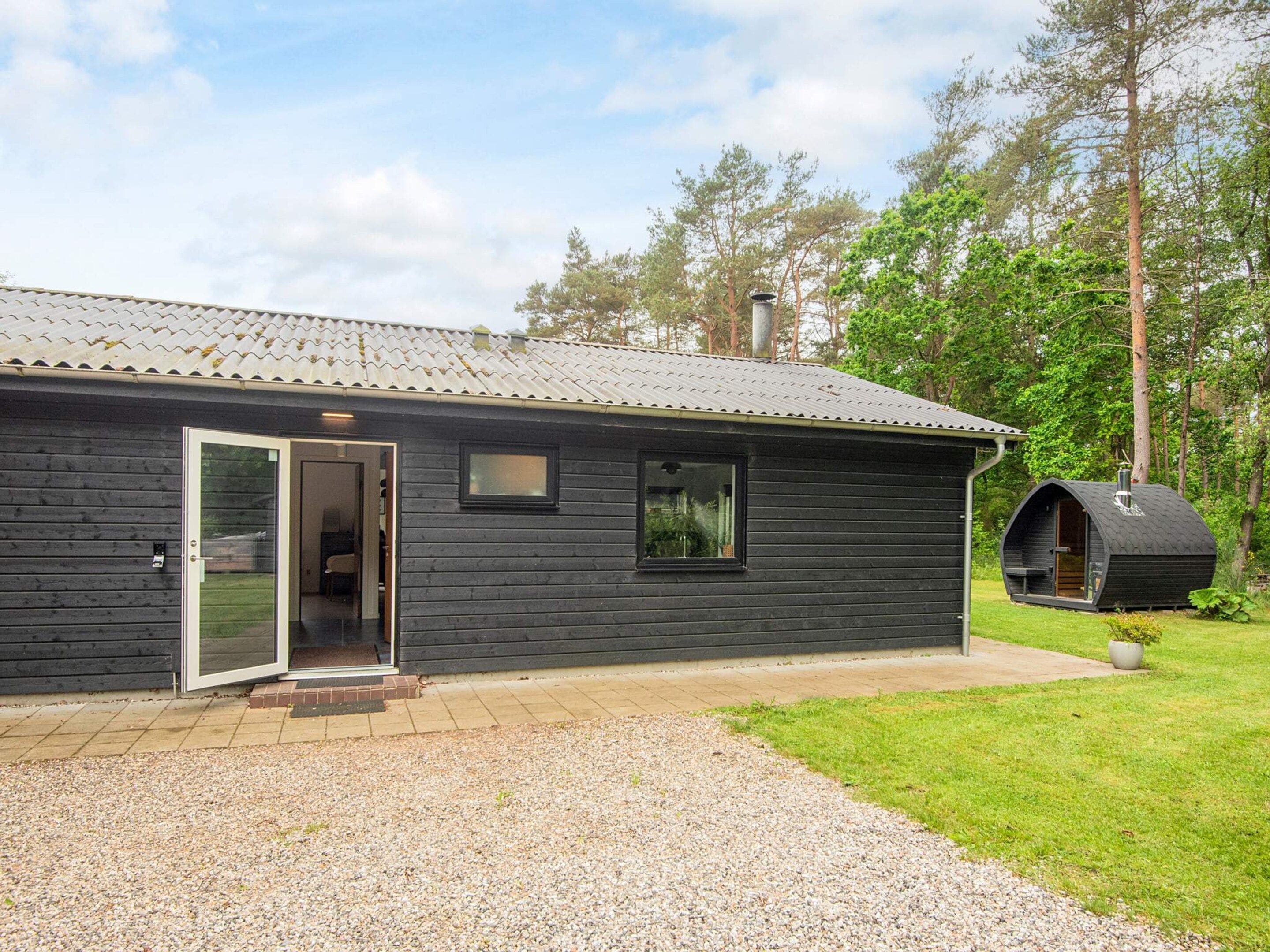 A cabin with a door, windows, and a small outdoor seating area.