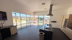 A modern kitchen with a large window, a sink, and a trash can. - Chic Urban Luxury Retreat 1Bedroom Apartment (Los Angeles)