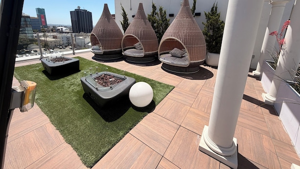A rooftop terrace with outdoor seating, a fire feature, and a view of the cityscape. - Chic Urban Luxury Retreat 1Bedroom Apartment (Los Angeles)