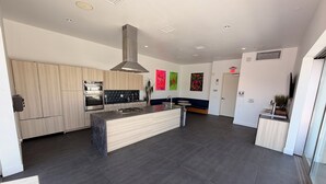 A modern kitchen with a central island, built-in oven, and a large range hood. - Chic Urban Luxury Retreat 1Bedroom Apartment (Los Angeles)