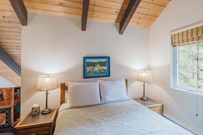 A bedroom with a bed, two bedside lamps, a framed picture on the wall, and a window with blinds. - Black Butte Retreat w Resort Amenities, Near Hiking and Bike Trails (Sisters)
