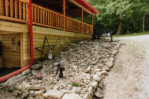 Eine Holzhütte mit Veranda, Bank und einem Kiesweg.