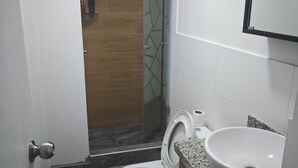 Ein kleines Badezimmer mit Toilette, Waschbecken und Dusche.
