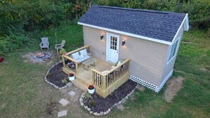 A small wooden house with a deck, a door, and a window. - Tiny House near Hillsdale College (Hillsdale)