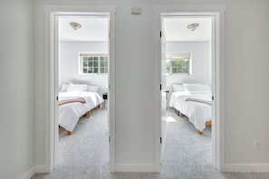 A room with two beds, a window, and a door. - Delightful 2-bedroom apartment in South Sandpoint perfect for your getaway. (Sandpoint)