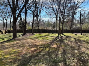 A wooded area with trees and a wooden fence. - Comfortable 4BR•2 King Beds• Near Arbor Place Mall (Douglasville)