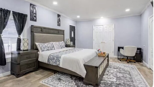 A bedroom with a bed, bedside tables, a desk, and a chair. - Comfortable 4BR•2 King Beds• Near Arbor Place Mall (Douglasville)