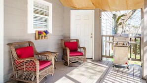 A covered porch with wicker chairs and a grill. - Comfortable 4BR•2 King Beds• Near Arbor Place Mall (Douglasville)