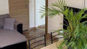 A room with a bed, a dining table with chairs, a potted plant, and a door. - Vilabahia, a peaceful getaway just a stone's throw from the sea (Sète)