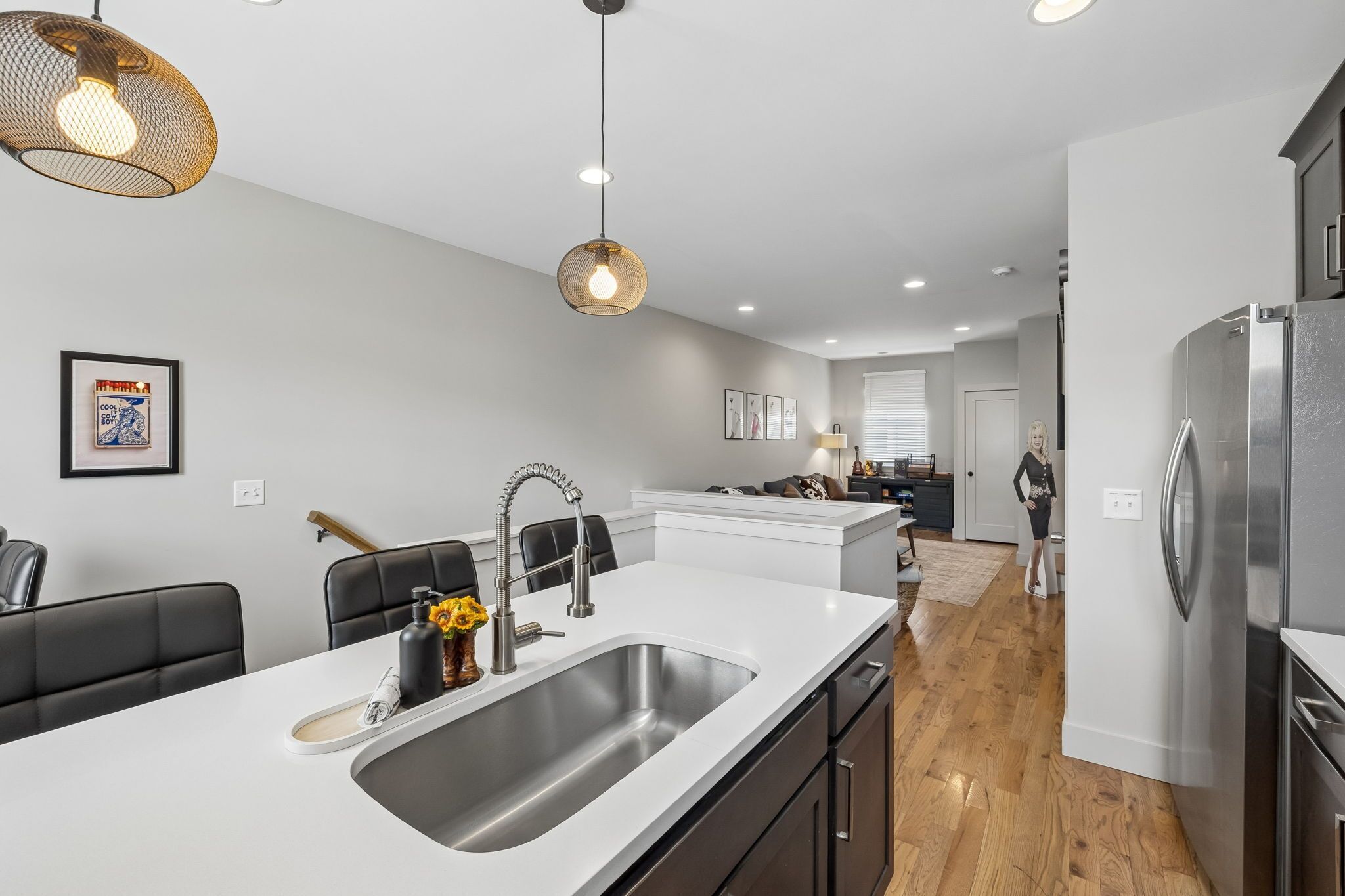 A modern kitchen with a central island, stainless steel appliances, and pendant lighting.
