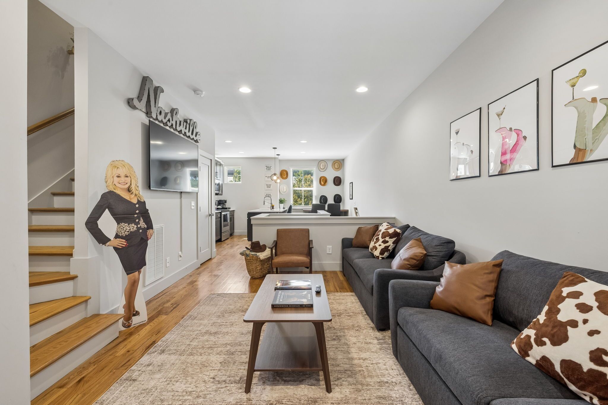 A modern living room with a sofa, coffee table, and a staircase.