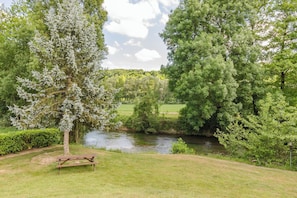 A park with a river, a picnic table, and dense greenery. - Le Gîte de la Vanne - Saint-Benoît-sur-Vanne (SAINT BENOIST SUR VANNE)