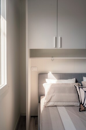 Ein Schlafzimmer mit Bett, Kleiderschrank und Fenster.