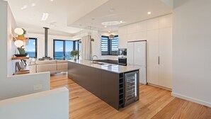 Een moderne keuken met een centraal eiland, inbouwapparatuur en uitzicht op het omliggende landschap.