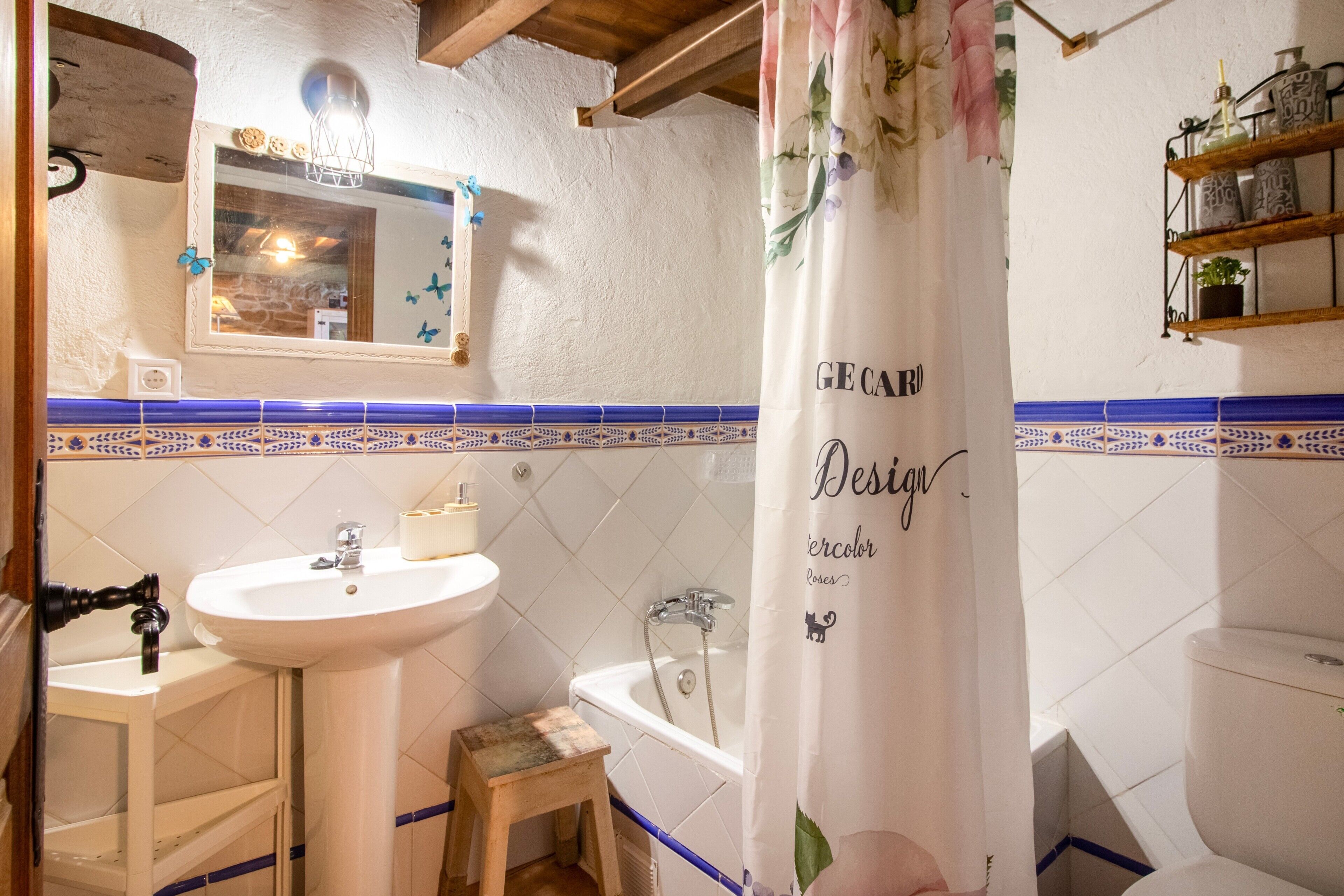 Un baño con lavamanos, espejo, ducha e inodoro.