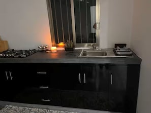 Una cocina moderna con estufa a gas, un lavamanos y armarios.