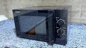 A black microwave oven with a digital display and control knobs on a granite countertop. - Diarna Lartin Residency 1 (Marsa Matrouh Governorate)