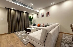 A modern living room with a sofa, coffee table, and a plant.