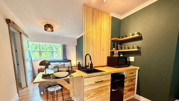 Una cocina moderna con encimera de madera, microondas integrado y un lavabo.