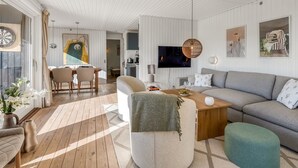 Un salon moderne avec un canapé, une table basse et un coin repas.
