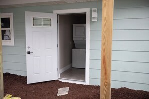 A house with a white door, a small window, and a visible laundry area. - The Woods at Coconut Cove (Fort Myers Beach)