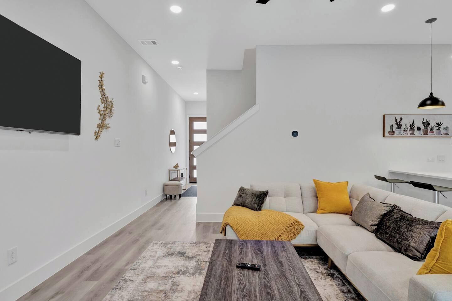 A modern living room with a sofa, coffee table, and a staircase leading to another level.