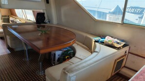 A compact living space with a sofa, a small table, and a window with a view of a building. - Enjoyable 4-bedroom boat with AC in vibrant Miami Beach (Miami Beach)