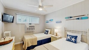 A bedroom with two beds, a ceiling fan, a TV, and a window with blinds. - Lee Ko 19 (Ocean City)