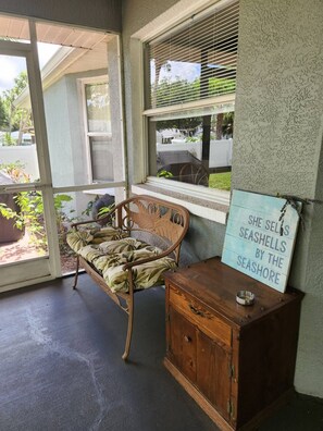 A room with a wooden bench, a cabinet, and a window with blinds. - Miss Ellie's Retreat (Port Charlotte)