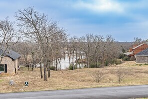 A residential area with a house near a body of water, surrounded by trees and a road. - Charming A-Frame Cabin:Water View & Large Yard,13 miles to Universal Kids Resort (Oak Point)