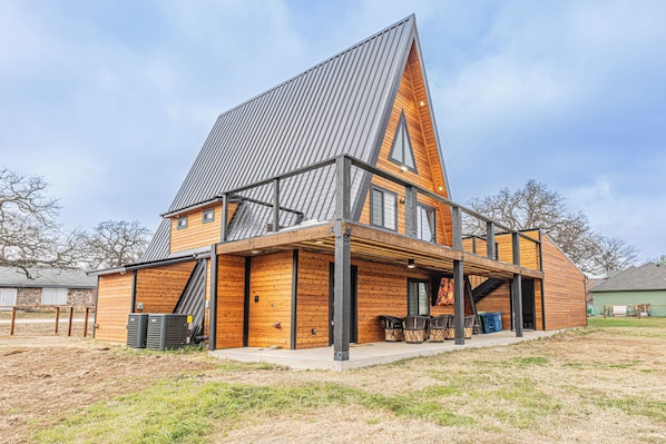A modern house with a sloped roof, a covered porch, and a visible staircase leading to the entrance.