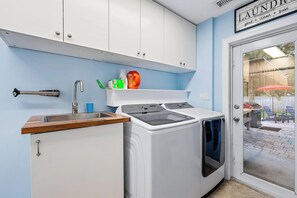 A compact kitchen with a built-in washer and dryer, a sink, and a small countertop. - Alabama- 4/3.5 (Hobe Sound)