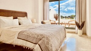 A bedroom with a large bed, a balcony with seating, and a view of the sky. - Casa de la Alegria, 3BD house near Cabopino Beach (Marbella)