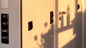 A door with a mirror, a keyhole, and a light switch.