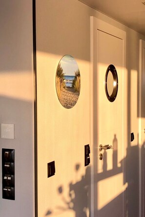 Una puerta con un espejo, un ojo de cerradura y un interruptor de luz.