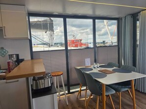 Una cocina moderna con un tostador, una cafetera y vistas al puerto a través de amplios ventanales.