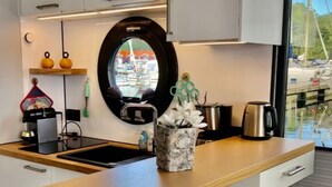 Eine moderne Küche mit einer Holzausziehtafel, einem Spülbecken und einem Fenster mit Blick ins Freie.