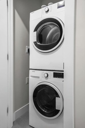 A stacked washer and dryer unit in a hallway. - Ridgeline | Slope-Side | Hot Tub | Resort Access (Panorama)