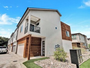 A modern two-story residential building with a garage, a balcony, and a small garden area. - Dallas Escape w/ Rooftop + Yard • Sleeps 10 (Dallas)