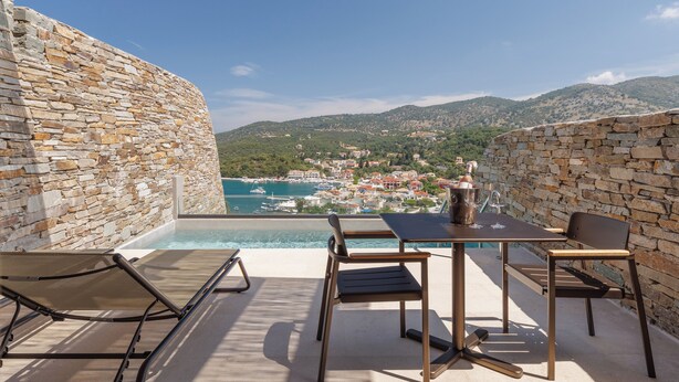 A stone-walled outdoor area with a pool, lounge chairs, and a table with chairs. - KHAI SYVOTA (Igoumenitsa)