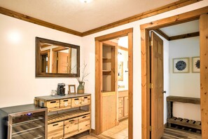 Eine Holztür, ein Spiegel, eine Kaffeemaschine und ein Schrank mit Schubladen.